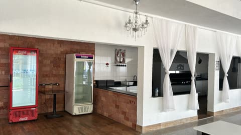 Cozinha equipada com bancada de granito, churrasqueira e expositores de bebidas