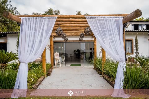 Entrada do salão de festas com pergolado de eucalipto e cortinas brancas para casamento