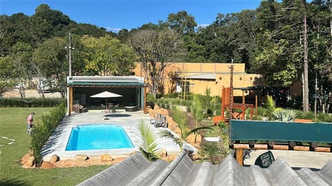 Piscina aquecida com deck, quiosque coberto e jardim tropical na Chácara Primeiro de Maio, em Colombo/PR